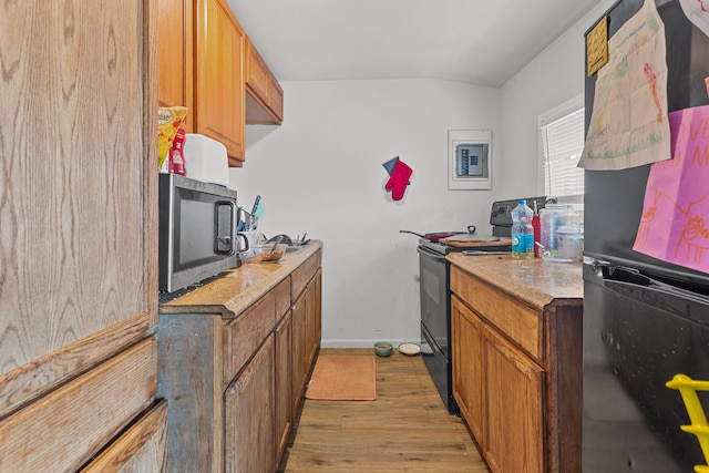 kitchen featuring black appliances, light wood-style floors, brown cabinets, and light countertops