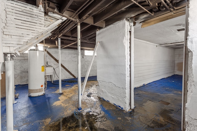 basement featuring gas water heater and a sink