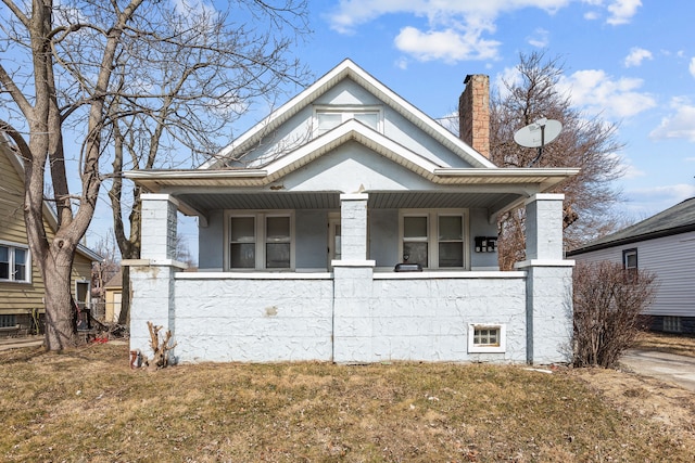 bungalow-style house featuring a porch and a chimney