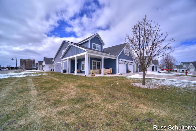 view of front facade featuring a garage, driveway, a porch, and a front yard