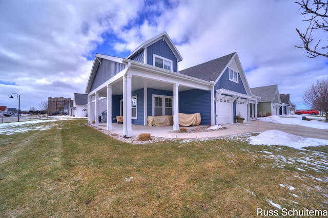 view of side of property featuring a garage, a yard, and driveway