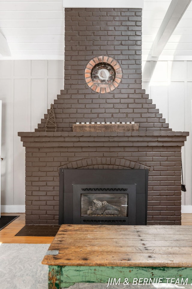 details featuring baseboards, wood finished floors, and a fireplace
