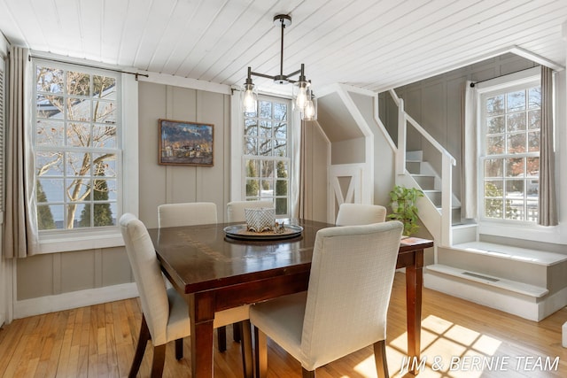 dining room with light wood-style floors, a healthy amount of sunlight, and a decorative wall