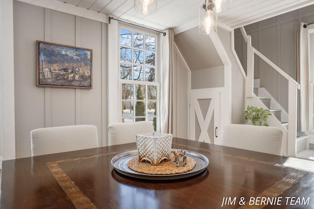 dining room featuring stairs and a decorative wall