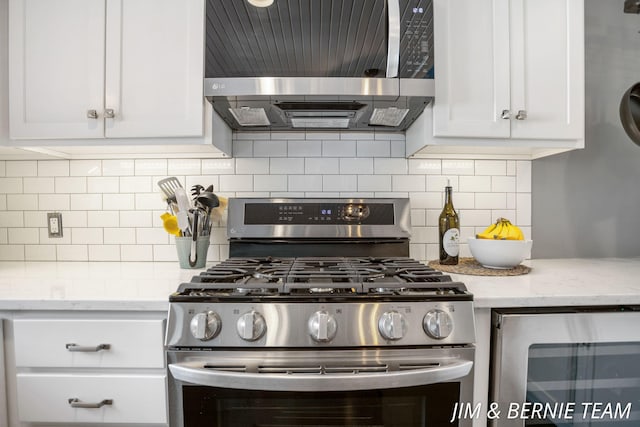 kitchen with stainless steel appliances, decorative backsplash, beverage cooler, and white cabinetry