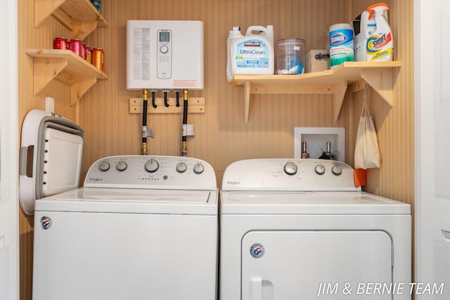 laundry room with wallpapered walls, washer and clothes dryer, and laundry area