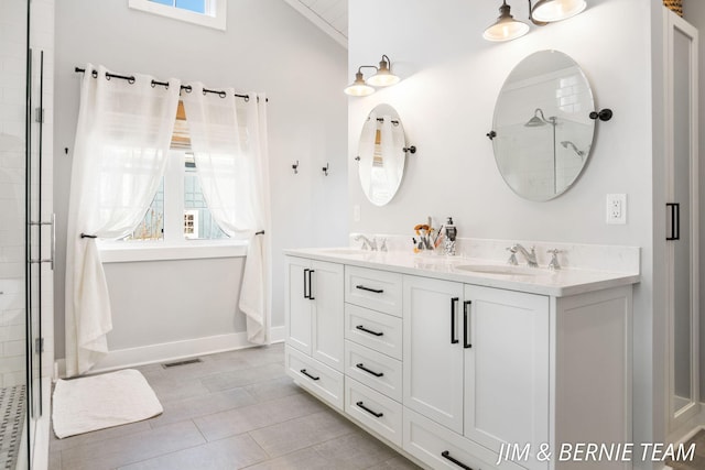 full bath with a sink, vaulted ceiling, double vanity, and visible vents