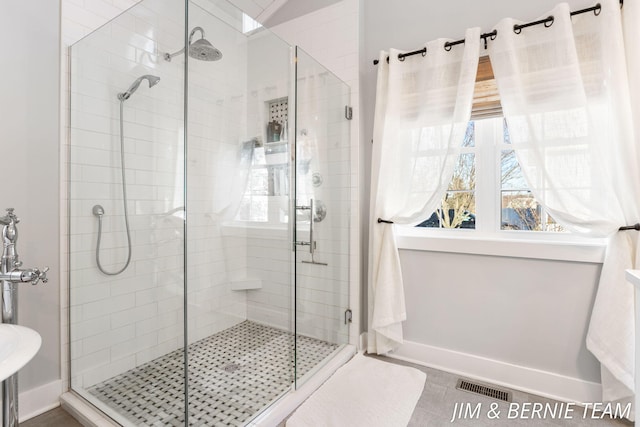 full bath with visible vents, a wealth of natural light, and a shower stall