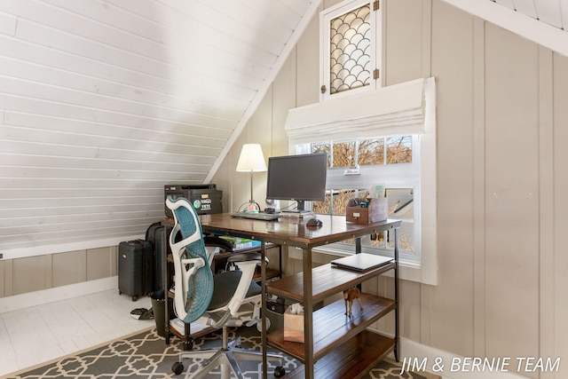 office area with lofted ceiling and a decorative wall