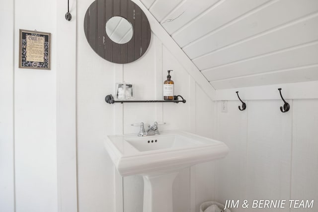 bathroom featuring a sink and lofted ceiling