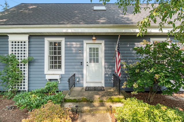 property entrance featuring a shingled roof