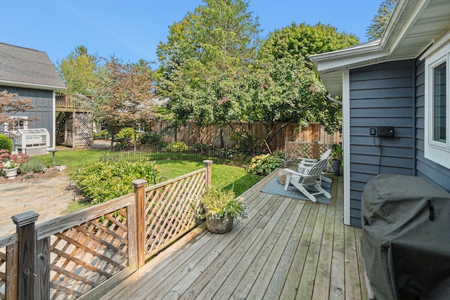 wooden terrace with a yard, a fenced backyard, and a grill