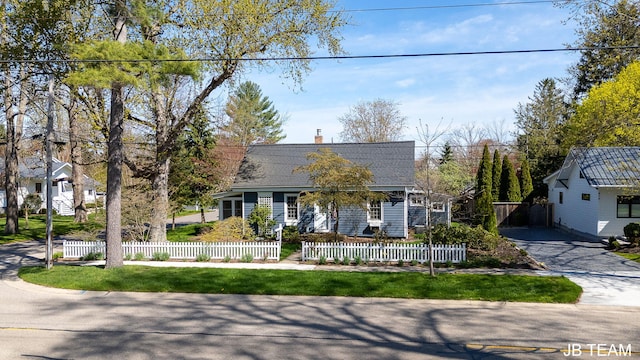 cape cod home featuring a fenced front yard and a chimney