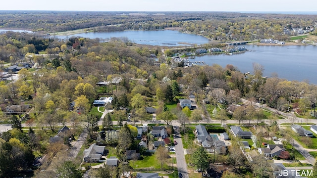 drone / aerial view with a residential view, a view of trees, and a water view