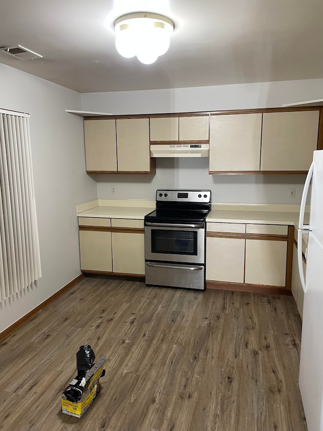 kitchen with dark wood-style floors, electric stove, visible vents, freestanding refrigerator, and under cabinet range hood