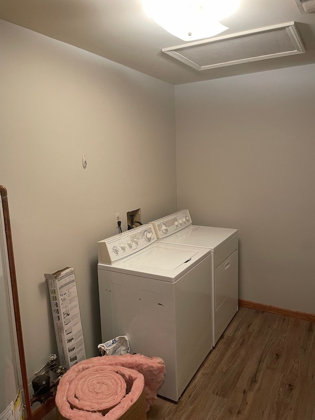 laundry room featuring laundry area, attic access, wood finished floors, and independent washer and dryer