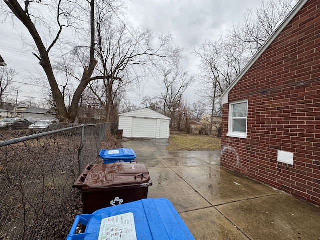 view of patio / terrace with an outbuilding, a garage, area for grilling, fence, and driveway