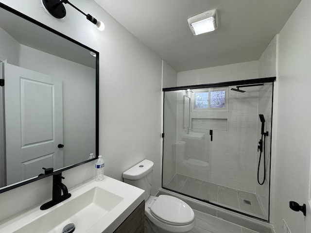 bathroom with vanity, a shower stall, and toilet