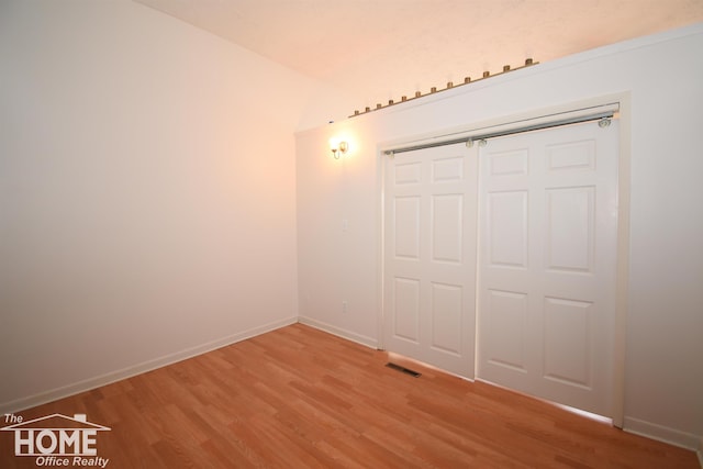 unfurnished bedroom featuring a closet, baseboards, visible vents, and light wood finished floors