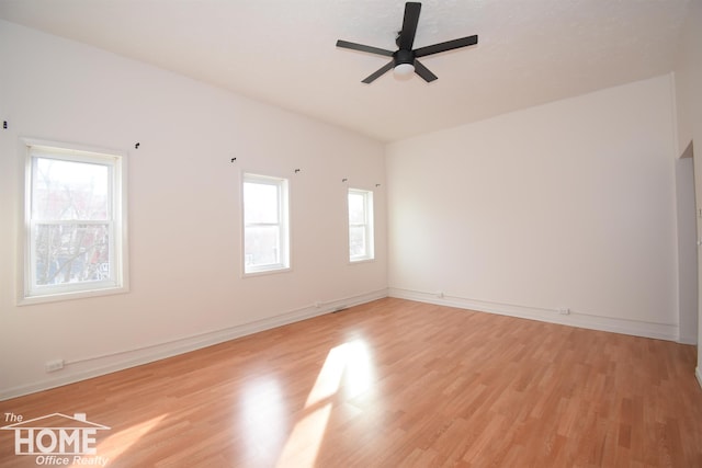 spare room featuring light wood-style floors, ceiling fan, and baseboards