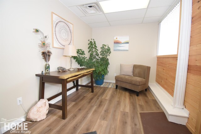 home office featuring visible vents, wood finished floors, a paneled ceiling, and baseboards