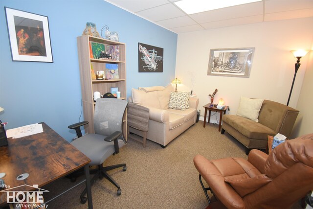 carpeted office space featuring a paneled ceiling