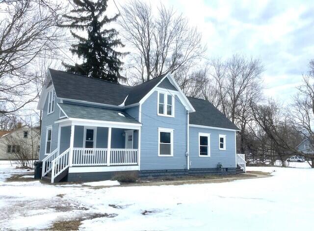 snow covered property with a porch