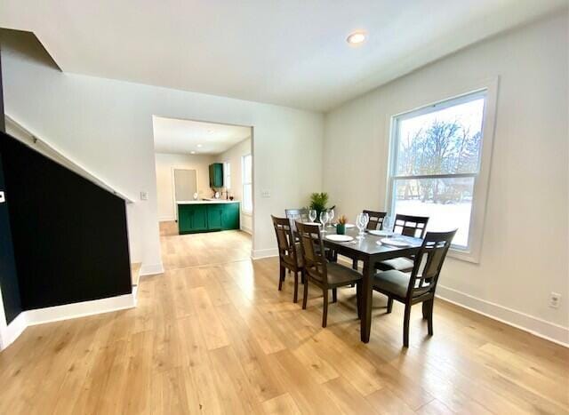 dining area with light wood-type flooring and baseboards