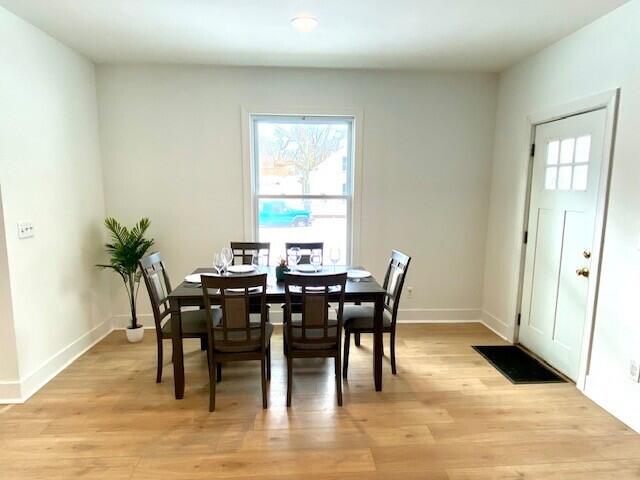 dining area with baseboards and light wood-style floors