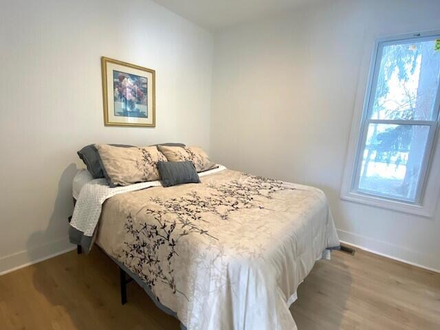 bedroom featuring baseboards and wood finished floors