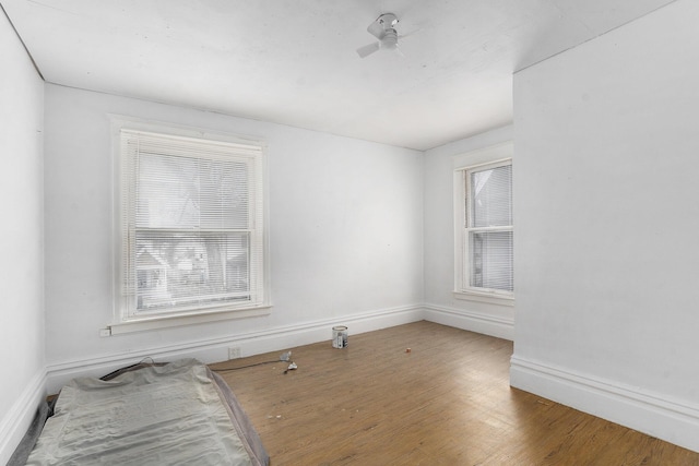 spare room with ceiling fan, wood finished floors, and baseboards