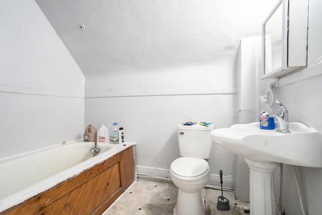 bathroom featuring a garden tub and toilet