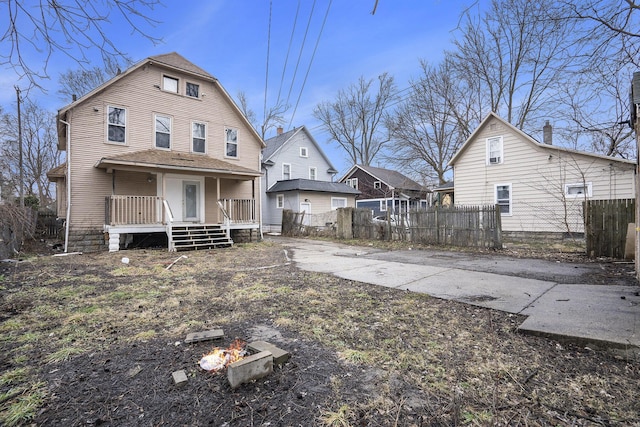 back of house with fence and a porch