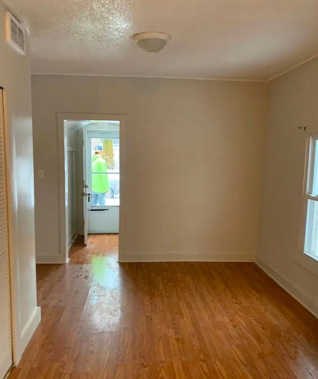 spare room featuring visible vents, baseboards, and light wood finished floors