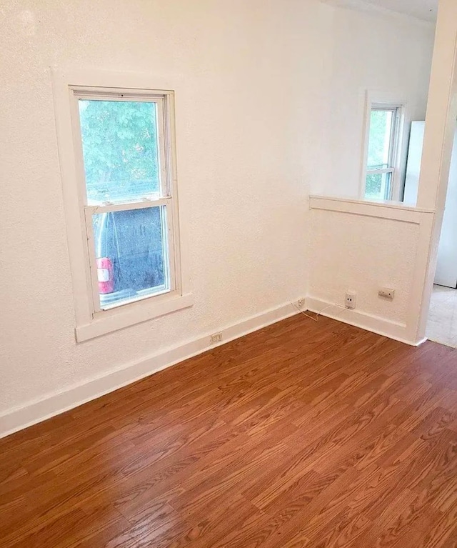 empty room featuring baseboards and wood finished floors