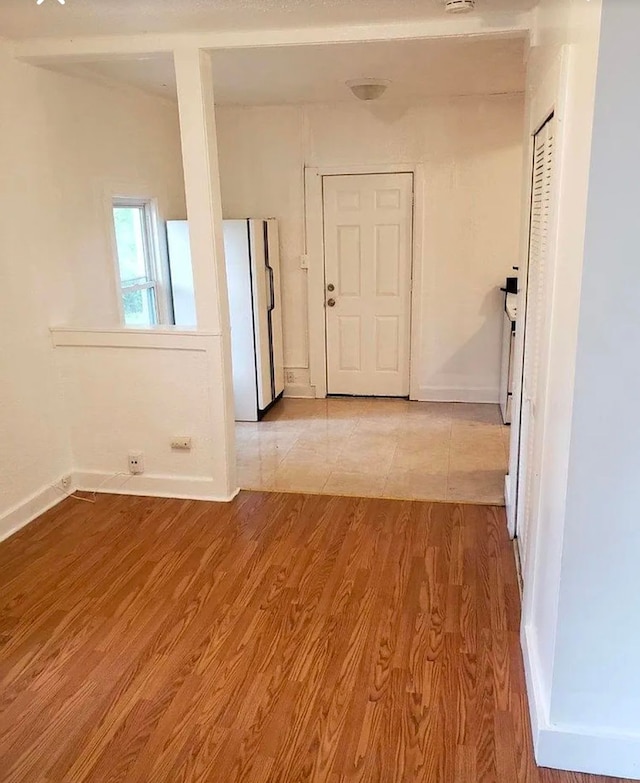 interior space featuring baseboards and light wood finished floors