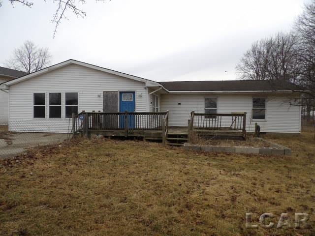 rear view of house with a deck and a lawn