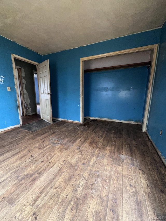 unfurnished bedroom with baseboards and wood finished floors