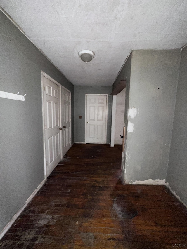 corridor featuring baseboards and wood finished floors