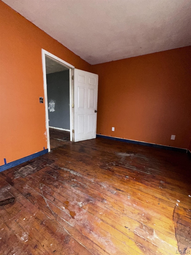 empty room featuring hardwood / wood-style floors and baseboards