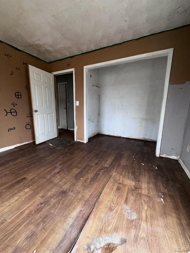 unfurnished bedroom with baseboards and wood finished floors