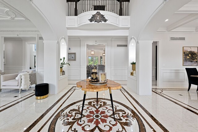 17965 Beck Rd, Northville, MI 48168 - entryway featuring marble finish floor, a decorative wall, crown molding, and wainscoting
