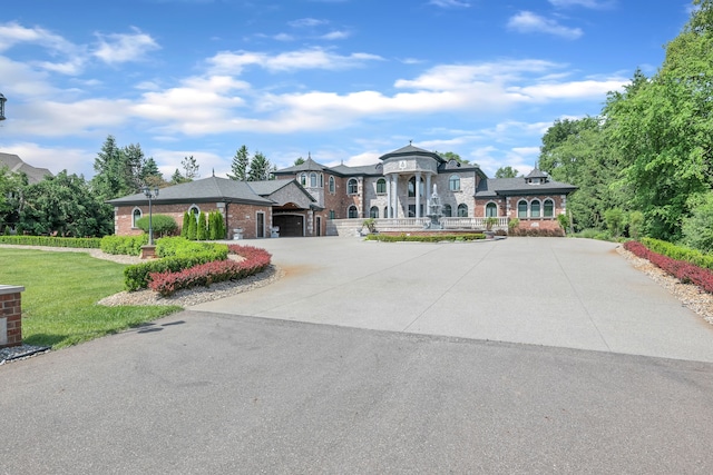 17965 Beck Rd, Northville, MI 48168 - view of front of property featuring a front lawn, an attached garage, brick siding, and curved driveway