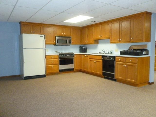 7433 E Maple Ave, Grand Blanc, MI 48439 - kitchen with stainless steel appliances, brown cabinetry, a sink, a drop ceiling, and light countertops