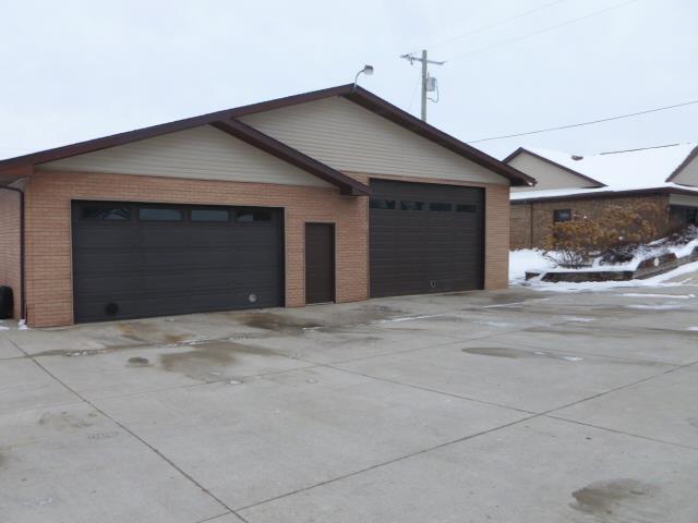 7433 E Maple Ave, Grand Blanc, MI 48439 - view of side of property featuring brick siding and a garage