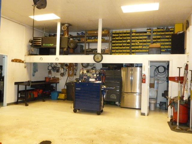 7433 E Maple Ave, Grand Blanc, MI 48439 - garage featuring freestanding refrigerator and a workshop area