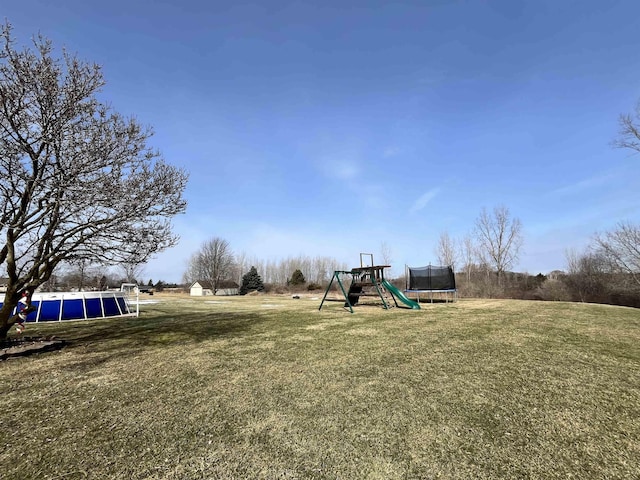 7433 E Maple Ave, Grand Blanc, MI 48439 - view of grassy yard with a trampoline and a playground