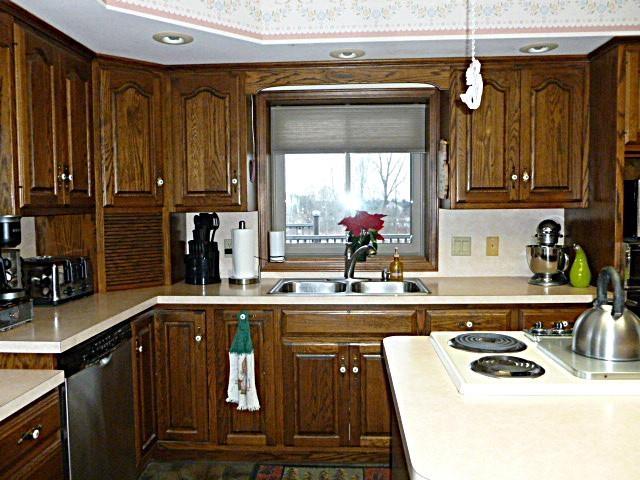 7433 E Maple Ave, Grand Blanc, MI 48439 - kitchen featuring a sink, dishwasher, light countertops, tasteful backsplash, and range