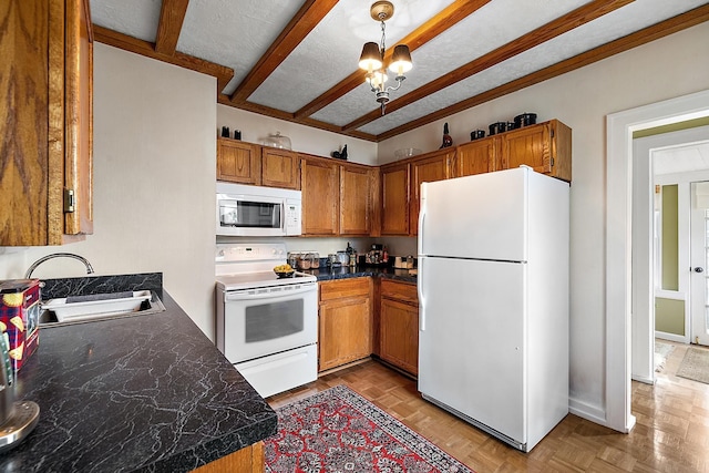 kitchen with brown cabinets, dark countertops, a sink, a chandelier, and white appliances