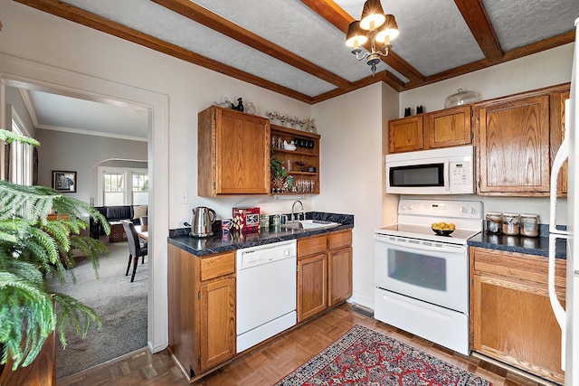 kitchen featuring arched walkways, white appliances, a sink, open shelves, and brown cabinetry